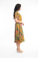 The Marmaris Godet Dress from Orientique has a v-neckline & short sleeves. It has godets to add fullness to the skirt & is a flattering calf length. It has a string tie & looks which can be tied at the back or at the front.