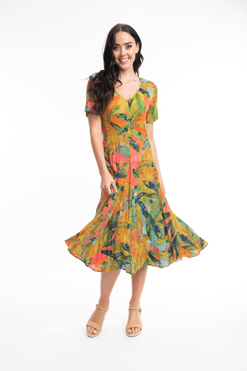 The Marmaris Godet Dress from Orientique has a v-neckline & short sleeves. It has godets to add fullness to the skirt & is a flattering calf length. It has a string tie & looks which can be tied at the back or at the front.