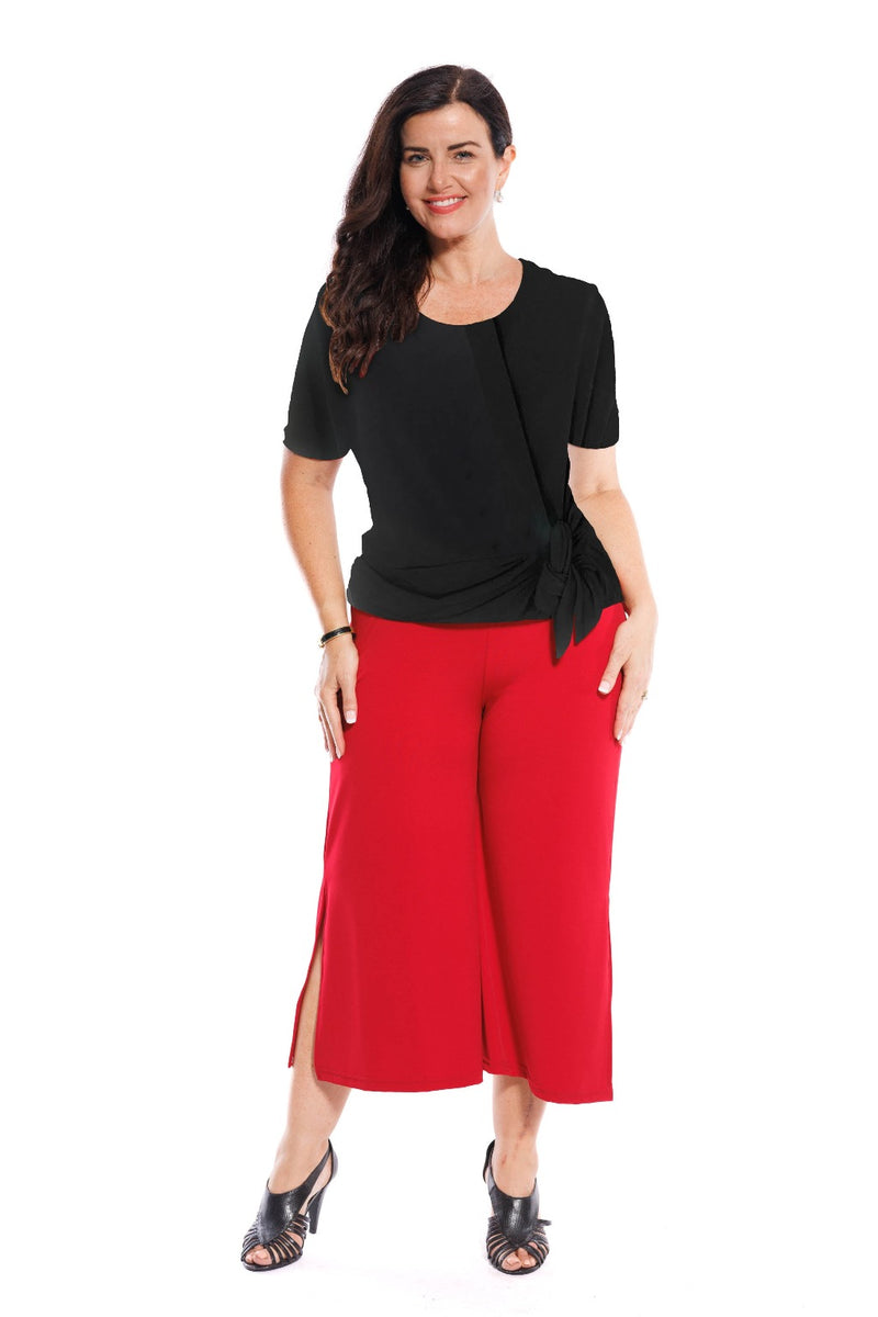 The Calabria stretch polyester Draped Front Top sits to the high hip. The flattering draped panel falls from the right shoulder down to the left waist with a self tie. It mixes & matches back with the Palermo Culotte, the Venice Slinky Pant, the long Black Panelled Skirt or black Bologna Knee Length Skirt.