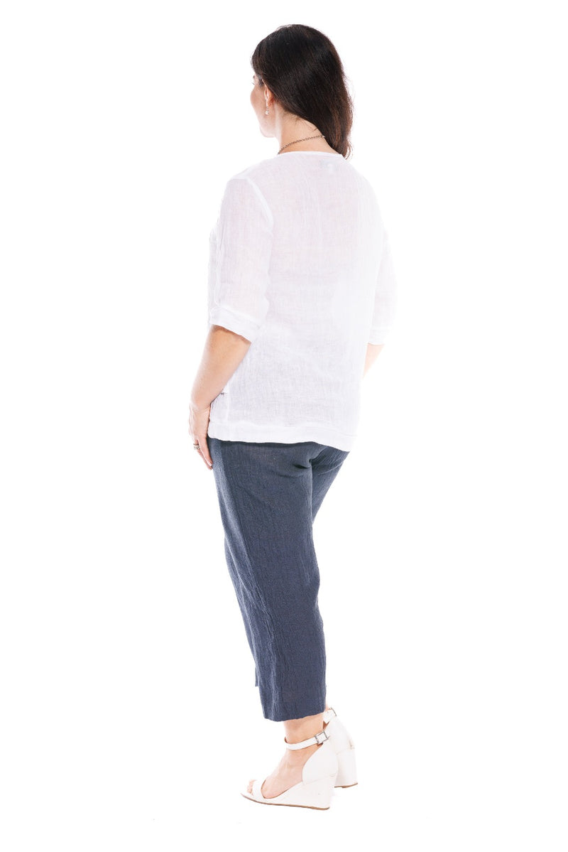 The Bara linen top is simple with a round neck, 3/4 length sleeves & an asymmetrical hem band detail. It is made in a lightweight, sheer crinkle finish fabric